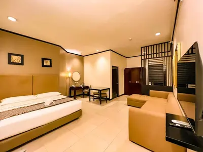 a bedroom with a bed and a couch and a desk at Casa Bocobo Hotel in Manila