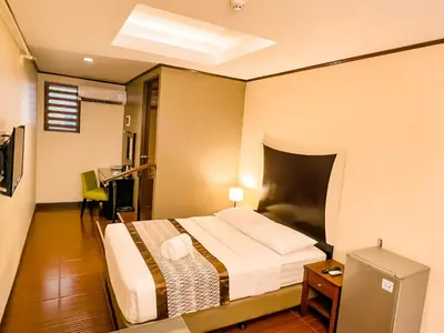 a hotel room with a bed and a desk at Casa Bocobo Hotel in Manila