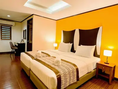 a bedroom with a large bed with an orange wall at Casa Bocobo Hotel in Manila