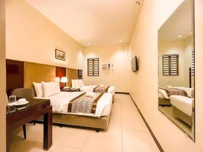 a hotel room with two beds and a desk at Casa Bocobo Hotel in Manila