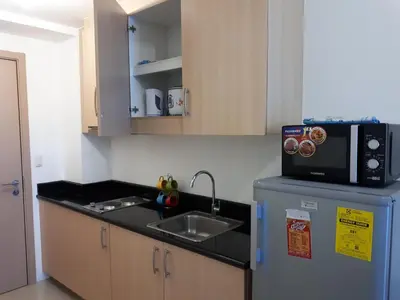 a kitchen with a sink and a microwave on top of a refrigerator at Light Residences 1BR Apartment Balcony in Manila