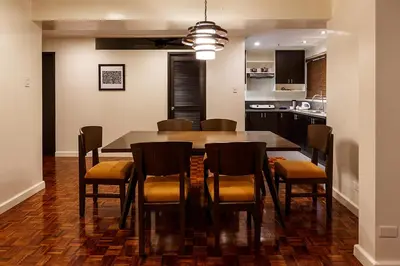 a kitchen and dining room with a table and chairs at Copacabana Apartment Hotel in Manila