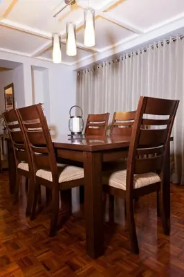 a wooden table with chairs and a tea kettle on it at Copacabana Apartment Hotel in Manila