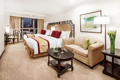a hotel room with a large bed and a couch at Discovery Suites Manila, Philippines in Manila