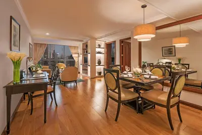 a dining room and living room with a table and chairs at Discovery Suites Manila, Philippines in Manila