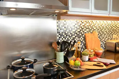a kitchen counter with pots and pans on a stove at Discovery Suites Manila, Philippines in Manila