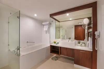 a bathroom with a tub and a sink and a mirror at Discovery Suites Manila, Philippines in Manila