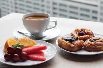 a table with two plates of pastries and a cup of coffee at Discovery Suites Manila, Philippines in Manila