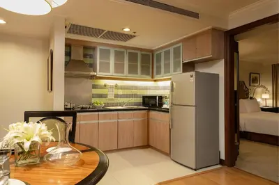a kitchen with a table and a refrigerator at Discovery Suites Manila, Philippines in Manila