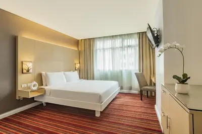 a hotel room with a bed and a window at St Giles Hotel Makati in Manila