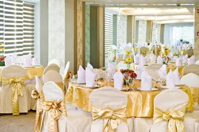 a banquet room with white tables and chairs with yellow bows at St Giles Hotel Makati in Manila
