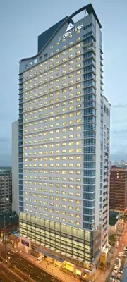 a tall building with a sign on top of it at St Giles Hotel Makati in Manila