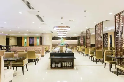 a dining room with tables and chairs in a restaurant at Swiss-Belhotel Blulane in Manila