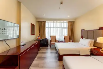a hotel room with two beds and a television at Swiss-Belhotel Blulane in Manila