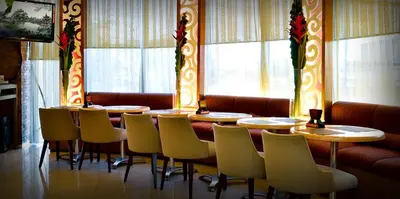 a row of tables and chairs in a restaurant at Networld Hotel Spa and Casino in Manila