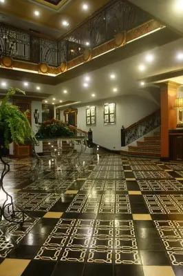 a lobby with a black and white floor and stairs at Herald Suites Polaris in Manila