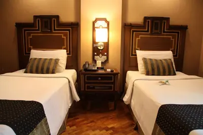 a hotel room with two beds and a nightstand between them at Herald Suites Polaris in Manila