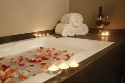a bath tub with candles and towels on a counter at Herald Suites Polaris in Manila