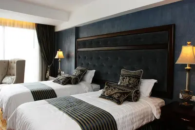 two beds in a hotel room with black walls at Hotel Celeste Makati in Manila