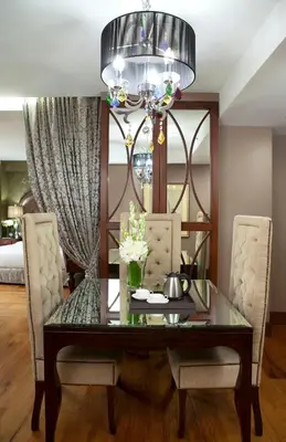 a dining room table with two chairs and a chandelier at Hotel Celeste Makati in Manila