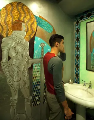 a man standing in a bathroom looking at a statue at Hotel Celeste Makati in Manila