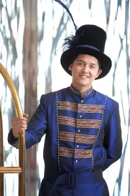 a young man in a blue suit and hat holding a wand at Hotel Celeste Makati in Manila