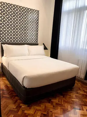 a bed in a bedroom with a black and white headboard at Parque España Residence Hotel in Manila