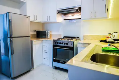 a kitchen with a stainless steel refrigerator and a sink at Parque España Residence Hotel in Manila