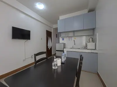 a kitchen with a table and chairs in a room at Alicia Apartment in Manila