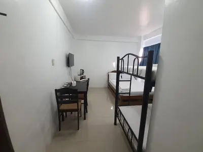 a room with two bunk beds and a table at Alicia Apartment in Manila