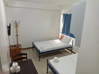 a small room with a bed and a chair at Alicia Apartment in Manila