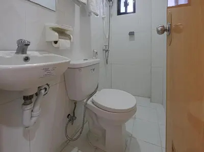 a bathroom with a toilet and a sink at Alicia Apartment in Manila