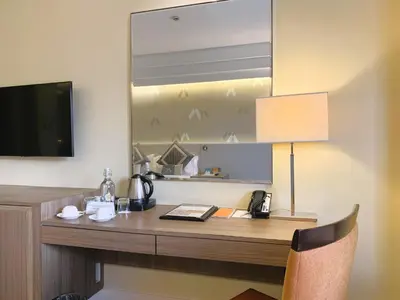 a desk in a hotel room with a lamp and a mirror at Hotel Benilde Maison De La Salle in Manila