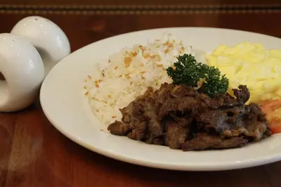 a plate of food with rice and meat and vegetables at Herald Suites in Manila