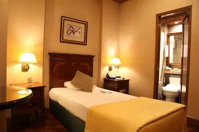 a hotel room with a bed and a bathroom at Herald Suites in Manila