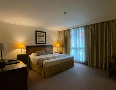 a bedroom with a large bed and a large window at Herald Suites Solana in Manila