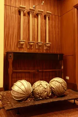 three pumpkins on a table in front of a organ at Herald Suites Solana in Manila