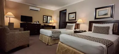 a hotel room with two beds and a television at Herald Suites Solana in Manila