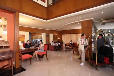 a group of people in a hotel lobby with luggage at Herald Suites Solana in Manila