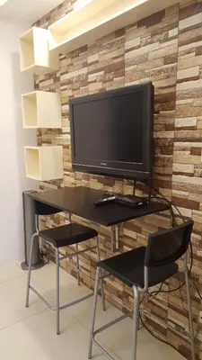 a computer desk with a monitor and a chair at Breeze Residences by CS Luxe in Manila