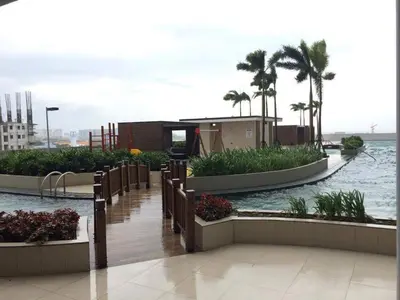 a building with a walkway next to a body of water at Breeze Residences by CS Luxe in Manila