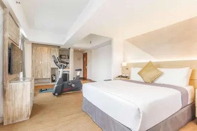 a bedroom with a large bed and a treadmill at TRYP by Wyndham Mall of Asia Manila in Manila