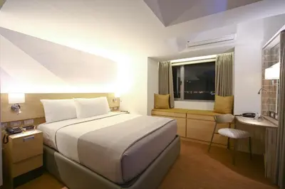 a hotel room with a bed and a desk at TRYP by Wyndham Mall of Asia Manila in Manila