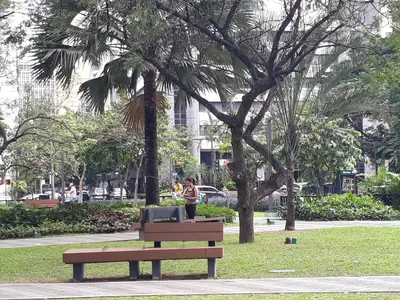 a person standing next to a bench in a park at KL Executive Greenbelt (KLX) in Manila
