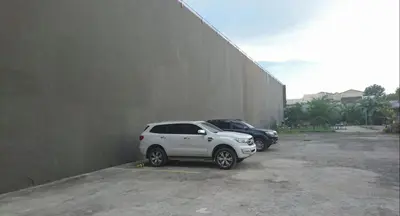 a white suv parked in a parking lot next to a wall at Calamba Pension Plaza in Calamba