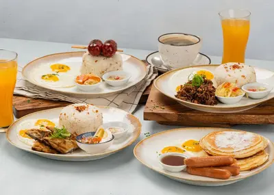 a table topped with plates of food and drinks at Richmonde Hotel Ortigas, Manila in Manila