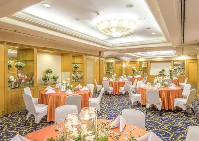 a banquet room with tables and chairs and a chandelier at Richmonde Hotel Ortigas, Manila in Manila