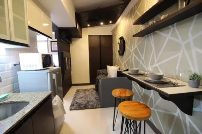 a small kitchen with a counter and two stools at 5E Tower 2 Viceroy in Manila