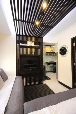 a bedroom with a fireplace with a black and white ceiling at 5E Tower 2 Viceroy in Manila