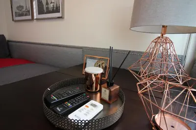 a table with a lamp and a remote control at 5E Tower 2 Viceroy in Manila